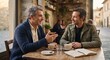 © Максим Новосветлов - Two mature men having a friendly conversation and drinking coffee together at an outdoor cafe table.