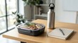 © PixelNova Studio  - Healthy lunch box with fresh food and metal water bottle on wooden desk in a bright modern home office. spill proof container