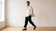 © Max_T - Full length portrait of a stylish young man walking in a bright minimalist studio