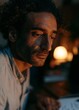 © CYBERPINK - Close-up portrait of a man with curly hair and a beard. he is looking off to the side with a serious expression on his face.