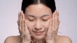 © mindminds - Young Asian woman washing face with water for daily skincare and facial hygiene routine
