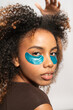 © Gonzalo Infiesta - Young woman applying under eye patches for skin care routine