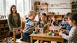 © Максим Новосветлов - Happy children playing with colorful wooden blocks in kindergarten classroom with teacher smiling.