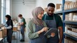 © AlfaSmart - Muslim woman and man managing food inventory on a tablet in a community warehouse. Diverse volunteer team organizing donated groceries for food bank distribution and nonprofit charity service.
