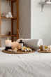 © Pixel-Shot - Wellness and relaxation therapy spa treatment setting with burning candles aroma diffuser rolled towel and plumeria flowers on a massage table