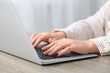 © Pixel-Shot - Woman working with laptop at table in office, closeup
