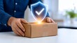 © wahyuni - Man holding cardboard box with digital shield icon for security