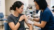 © Cahya - Female nurse applying alcohol pad to patient arm rolling up sleeve for vaccination in clinic, medical procedure concept