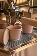© The Little Hut - Close-up of espresso machine brewing rich coffee into stylish pastel cups, inviting cafe ambiance