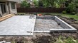 © MdZakirHossain - Backyard patio construction project with stone pavers and retaining wall installation in residential garden setting