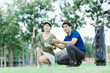 © Tj - Golf instructor teaching young woman putting technique on green, explaining strategies and giving advice for game improvement, enjoying sports and leisure activity outdoors