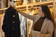 © veronica - Store owner checking clothes inventory using digital tablet