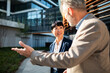 © Davor - Business colleagues discussing strategy outside modern office