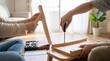 © Tanvir - Close Up Of Hands Assembling Wooden Table Furniture With Screwdriver At Home