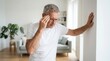 © Zaiseefa - Grey-haired middle age man standing at home while suffering dizzy
