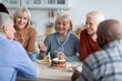 © Prostock-studio - Smiling Senior Women Having Joyful Conversation While Drinking Coffee And Eating Cake Together At Kitchen Table In Home Setting. Celebrating Friendship And Connection. Weight Loss Concept.