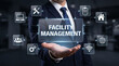 © Anjana444 - Businessman holding a futuristic transparent interface for facility management