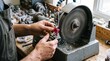 © Cahya - Jeweler hands using a grinding machine wheel with water splash while shaping a raw ruby representing precision gemstone lapidary craft and artisanal jewelry manufacturing.