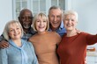 © Prostock-studio - Smiling Group Of Five Elderly Friends, Including Two Males And Three Females, Posing Together At Home, Celebrating Friendship And Happiness In A Bright Kitchen Setting. Positive Lifestyle Concept.