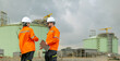 © BESTIMAGE - Teamwork technician discussing petroleum engineering in oil refinery project collaboration at fuel industrial plant Male and female engineers holding laptop talking near petrol storage tanks