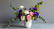 © Md - Fresh bouquet of colorful flowers in a vase - A vibrant flower arrangement featuring roses, ranunculus, and anemones in a simple white vase with green foliage.
