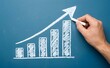 © Cgeeks - Hand drawing upward trending bar graph with arrow on a blue background