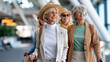 © Nataliya - Joyful group of cheerful faceless senior women all smiles eagerly preparing for their exciting journey at airport, defocused elderly travel excitement, mature friendship