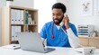 © Panpatsa - Veterinary clinic interior featuring a handsome african american man in scrubs multitasking with a computer and phone.