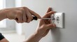 © Angavlan - Electrical outlet installation with screwdriver in wall. Certified electrical outlet installation involves securing plate into modern socket. Precise electrical outlet installation for safety at home.
