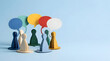 © Bunga - Conceptual teamwork discussion and customer feedback session with colorful paper cutout figures and speech bubbles on a blue background.