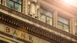 © Mr Stock - Historical bank building exterior with ornate stone architectural detailing under bright sunlight, captured in an upward perspective shot b 26