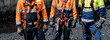 © Parilov - Construction workers in safety harnesses and high visibility gear for site team background and safety banner, insurance for working at height