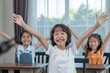 © BESTIMAGE - Happy children participating in STEM classroom activity raising hands with excitement showing active learning and engagement education. Group of joyful kid students celebrating project at school.