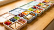 © Nelly - Meal prep boxes hold sandwiches, wraps, fruit, vegetables, nuts, and snacks. Filled lunch boxes line a wooden counter. Weekly planning supports healthy eating.