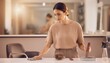 © EBG Stock Studio - Mujer limpiando una mesa con un paño en un espacio interior moderno y luminoso con mobiliario desenfocado al fondo