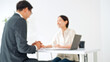© metamorworks - A man and a woman in a meeting. Blurred image for illustrative purposes. Customer service, consultation, business, sales, client, B2C, handshake, contract, sales transaction.