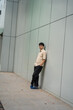 © Firman Maulana Ihsan - A young man stands against a modern building with a sleek, glass facade.