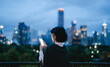 © dodotone - Business asian woman relax using smartphone social network communication metropolis city building background