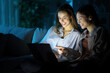 © PheelingsMedia - Happy women watching media on laptop in the night