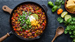 © Harmaen - Tasty chili con carne in a frying pan on a grey background