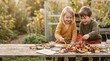 © Alva - Two young children laughing while painting with autumn leaves at a wooden garden table.