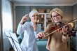 © Migma_Agency - Senior women enjoying music lesson and friendship at home