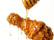 © Safikul Islam - Honey drizzled over a crispy fried chicken drumstick isolated on white background