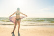 © Maria - Woman standing with towel on the beach with ocean on background