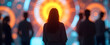 © Oleksandr - Silhouette of a person standing before a large futuristic glowing display screen filled with vibrant orange and blue circular patterns, representing modern technology, innovation, and digital data con