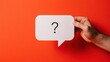 © Shahriar - A hand holds a speech bubble with a question mark on a vibrant red background. Perfect for business uncertainty and problem solving concepts.