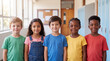 © Ankit - Diverse group of happy elementary school children standing together in a school hallway.