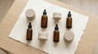 © rezaul4022 - Natural cosmetic bottles and jars with dropper pipettes for skincare products on white paper mat
