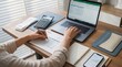 © Stock iT - Professional accountant hands working on laptop with financial spreadsheet invoice calculator and tax documents on desk.