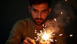 © Nataly - Man with sparkler closeup, man with sparkler held in hand by focused young man with beard, glowing sparks, smoke plume and warm bokeh lighting,